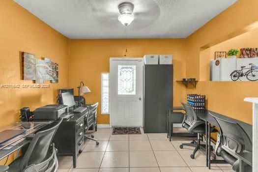 Entryway featuring large-format tile flooring, a glass-paneled exterior door, a central ceiling-mounted light fixture, and a built-in recessed wall niche