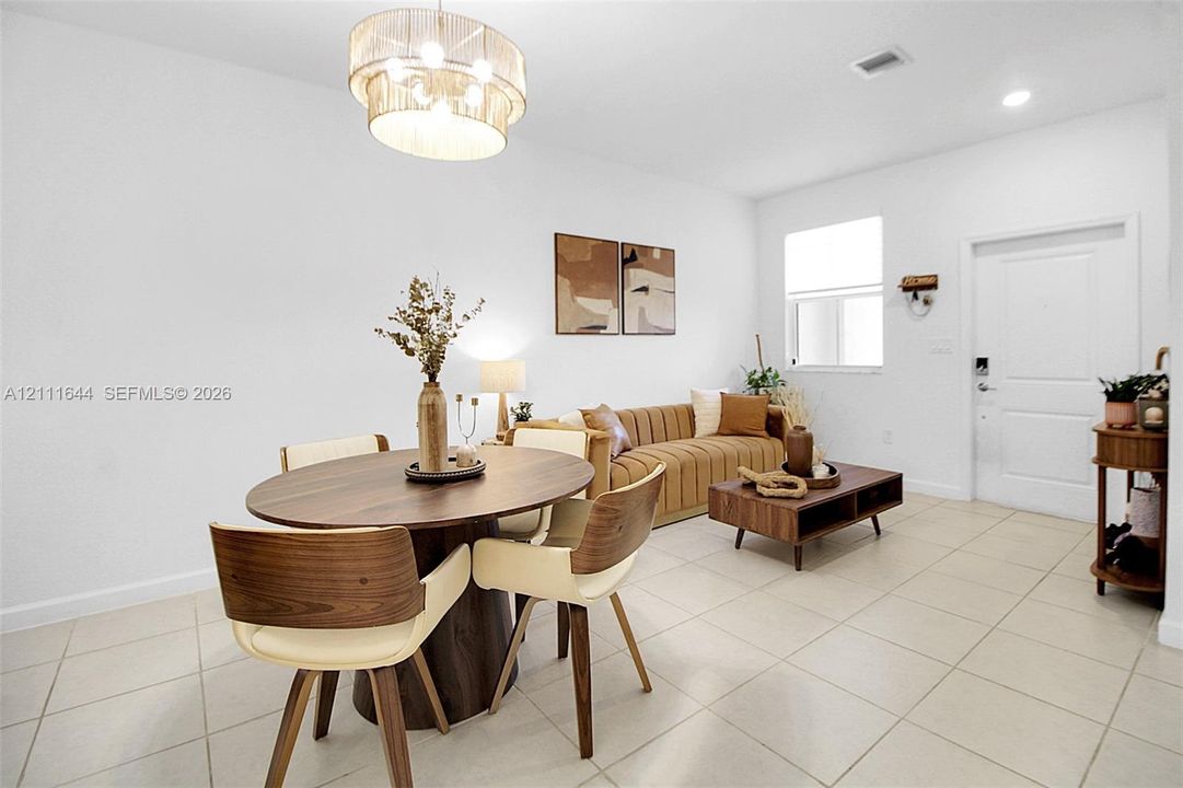 Neutral ceramic tile flooring, multi-tiered drum pendant lighting, and a single-panel interior door