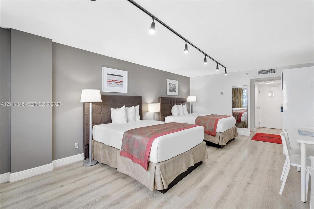 Wood-finish flooring, neutral wall tones, and overhead track lighting