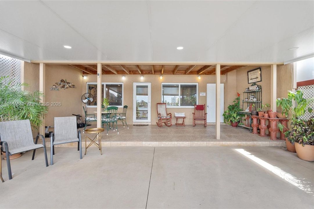 Covered patio featuring recessed lighting, a concrete floor, and tile surfacing