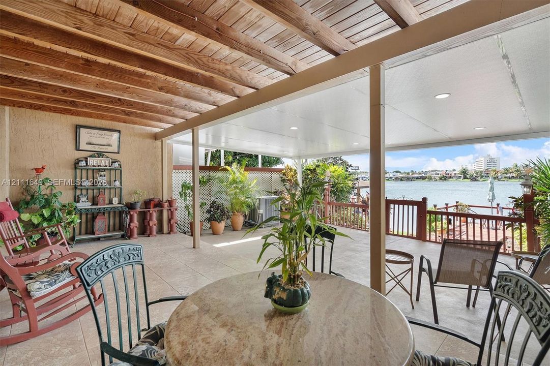 Covered patio featuring a wood-plank ceiling, recessed lighting, tile flooring, and a decorative wood railing