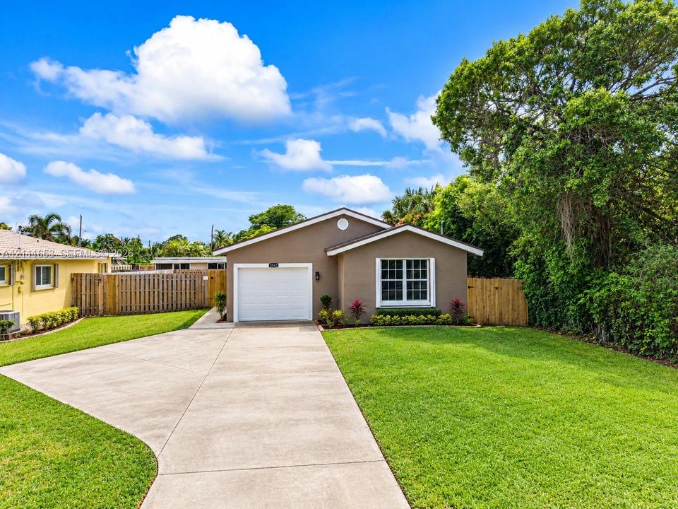 Single-story residence featuring a concrete driveway, attached one-car garage, and wooden privacy fencing
