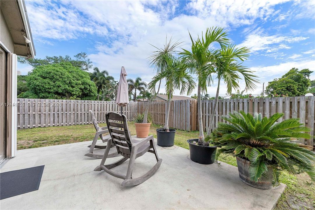Concrete patio space enclosed by wood privacy fencing