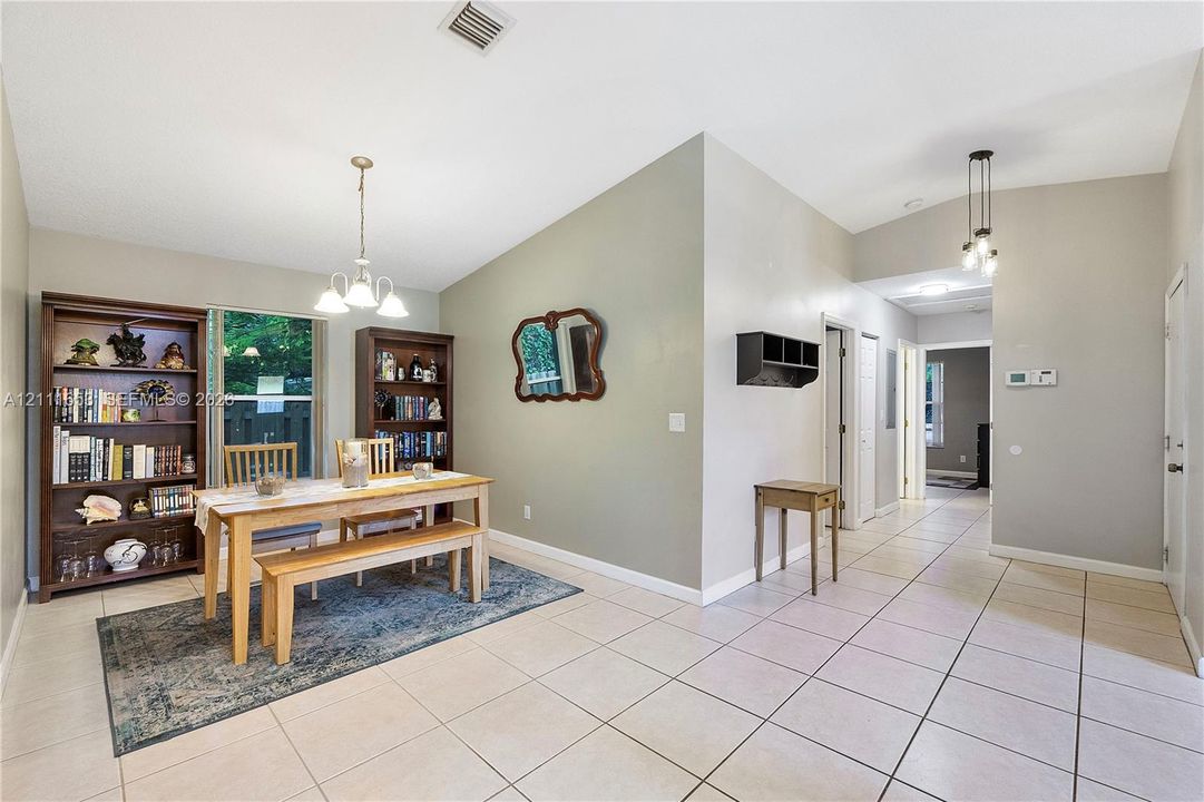Formal Dining with vaulted ceilings, large-format tile flooring, and multi-light pendant fixtures
