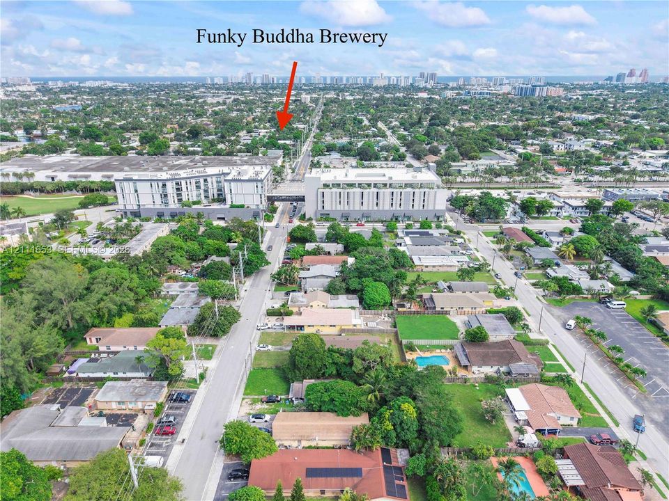 Just a stone's throw from Oakland Park's Funky Buddha Brewery, aerial perspective of the urban neighborhood featuring established tree canopy, paved roadway infrastructure, residential properties