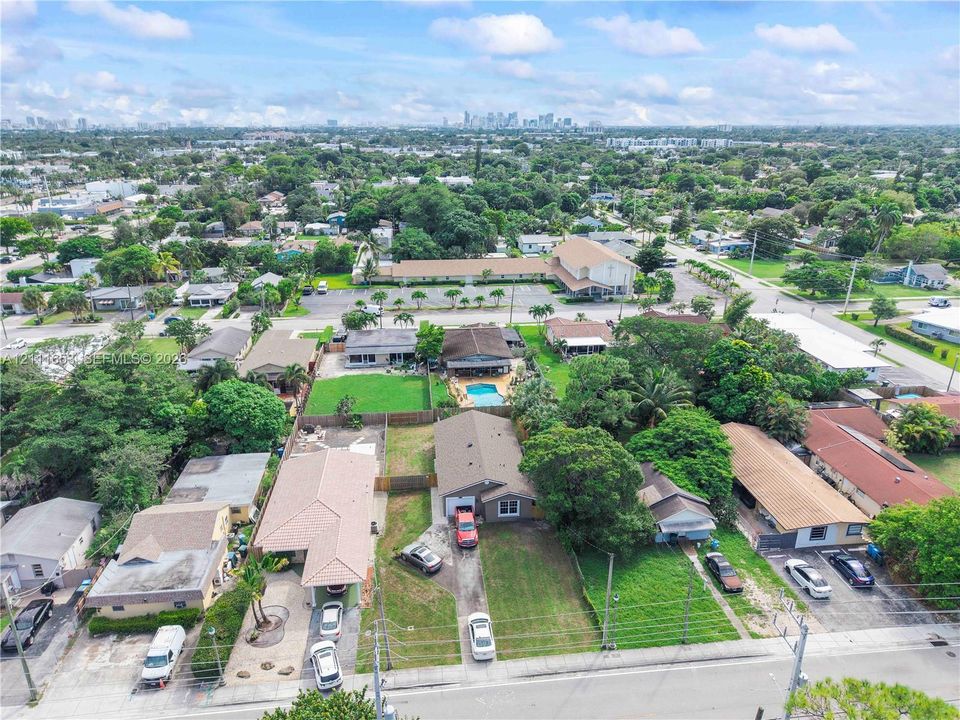 Aerial perspective featuring expansive residential lots with mature trees, established landscaping, and paved driveways