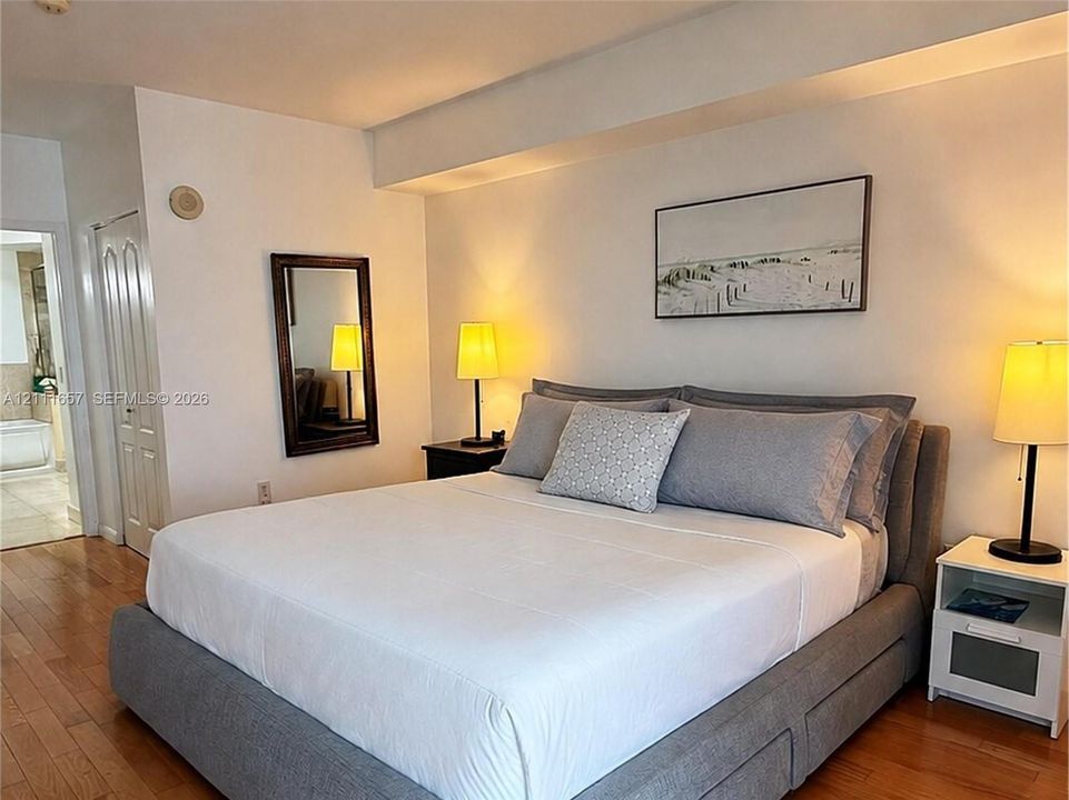 Wood-finish flooring throughout, smooth ceiling, and multi-panel interior door