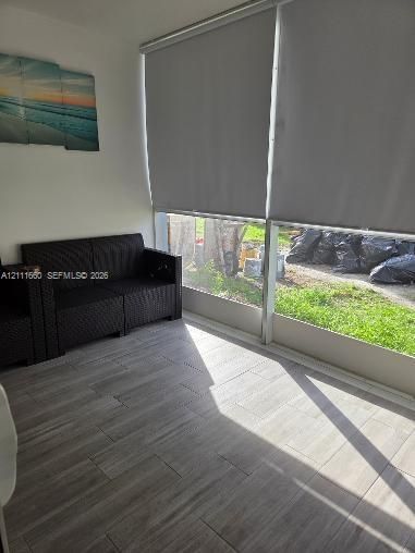 Interior space featuring ceramic-finish tile flooring and floor-to-ceiling windows equipped with roller shades