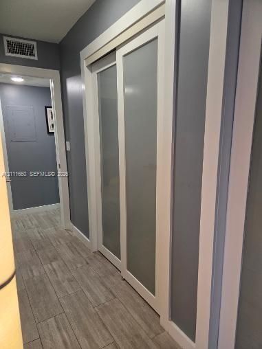 Sliding doors featuring white frames and frosted glass panels, wood-finish flooring, and recessed ceiling lighting