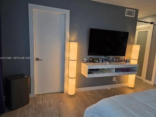 Wall-mounted white floating media console, ceramic-finish flooring, and crisp white interior doors with satin nickel hardware