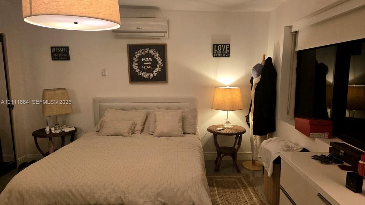 Wall-mounted ductless air conditioning unit, large drum pendant lighting fixture, and window with built-in shade