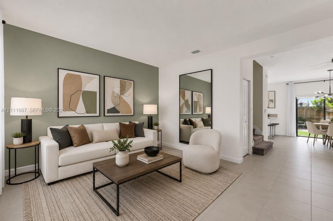 Living area featuring an accent wall, neutral tile flooring, and large-format glass sliding doors