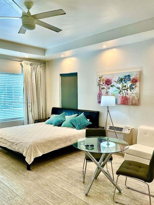 Tray ceiling with recessed lighting, wood-finish flooring, and ceiling fan