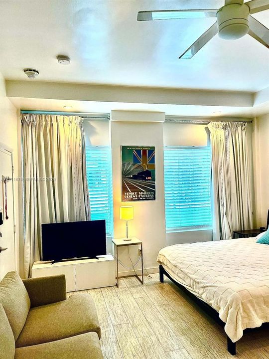 Room featuring wood-finish tile flooring, recessed ceiling lighting, and a modern ceiling fan