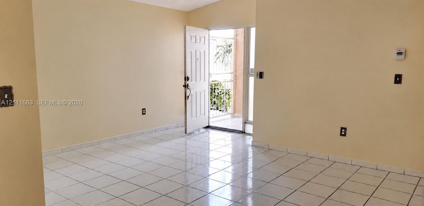 Interior space featuring polished white tile flooring and a multi-panel entry door