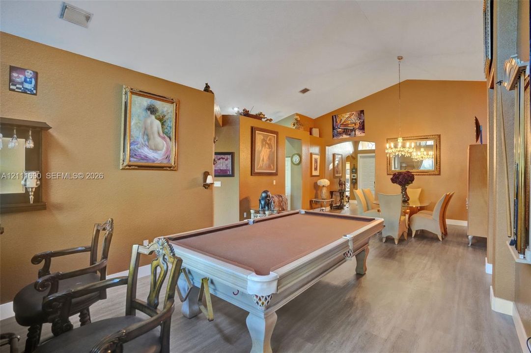 Vaulted ceilings, wood-finish flooring, and a multi-arm chandelier