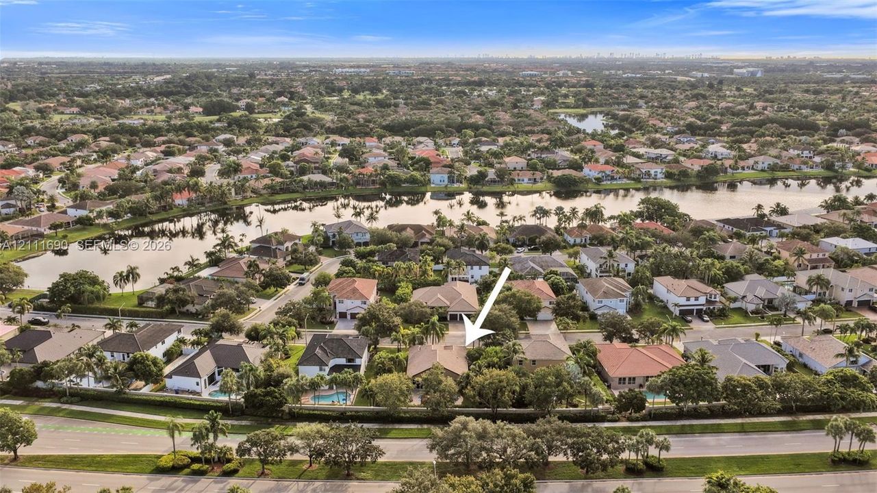 Aerial perspective showcasing a residential property with a tiled roof, mature landscaping, and an expansive backyard