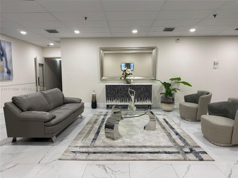 Large-format tile flooring with marble-style veining, recessed ceiling lighting, and a neutral wall finish
