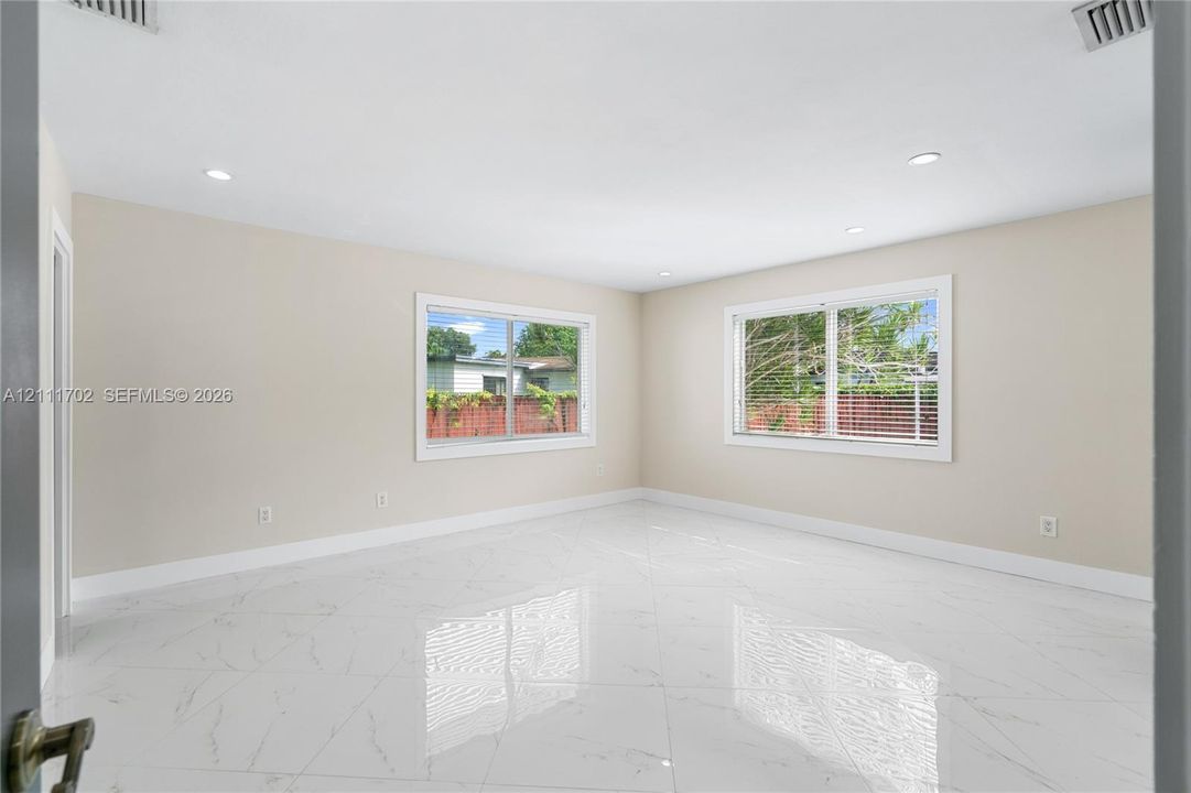 Spacious interior featuring large-format tile flooring, recessed lighting, and expansive windows