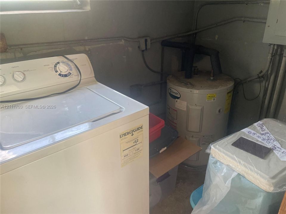 Utility area featuring a top-load washer and a vertical water heater