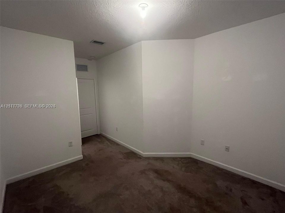 Interior space featuring neutral wall tones, wall-to-wall carpeting, and a multi-panel door