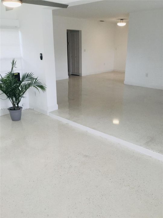 Polished concrete flooring, split-level floor plan, flush-mount ceiling lighting, and louvered bifold closet doors