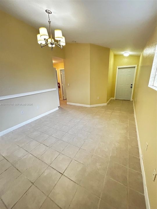 Ceramic tile flooring, multi-arm chandelier, and decorative chair rail molding