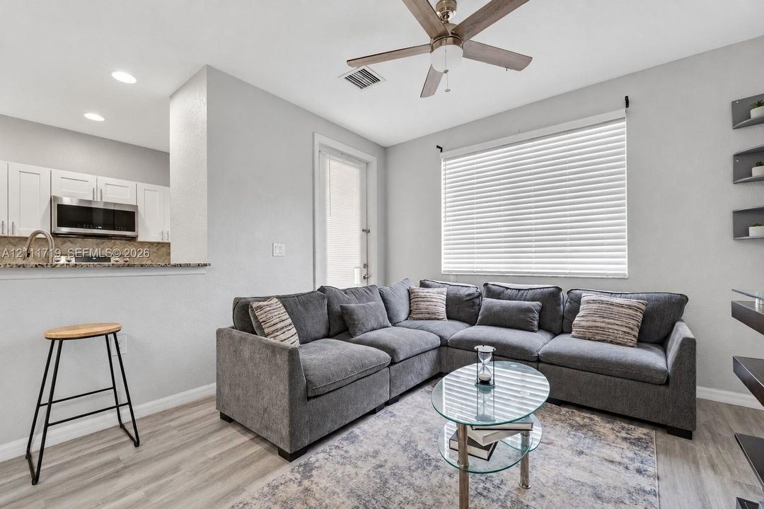 Open-concept space featuring wood-finish flooring, a ceiling fan, horizontal window blinds, and recessed lighting