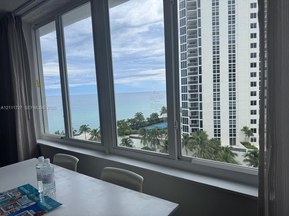 Expansive floor-to-ceiling windows featuring white metal framing and a wide interior sill