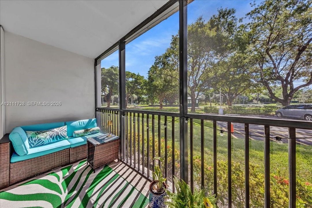 Screened-in balcony featuring black metal railings and overhead lighting