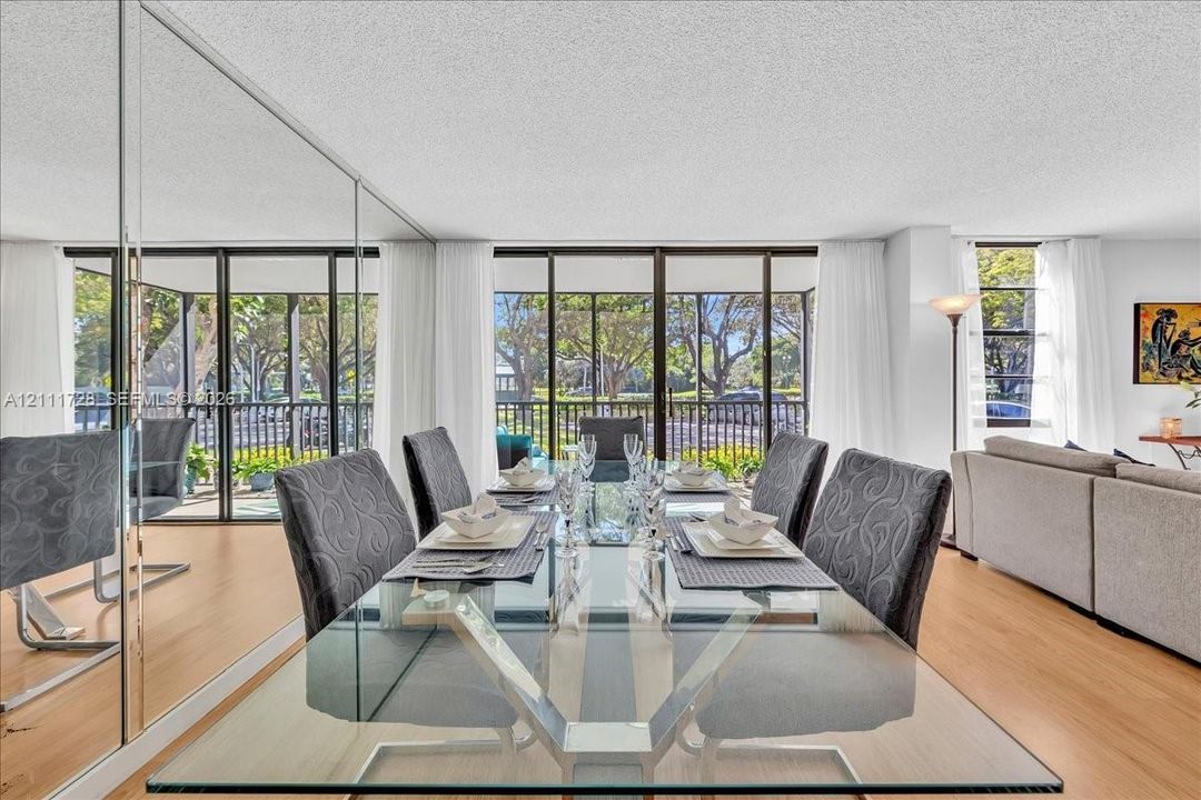 Floor-to-ceiling mirrored wall, wood-finish flooring, and expansive glass sliding doors featuring screen enclosures