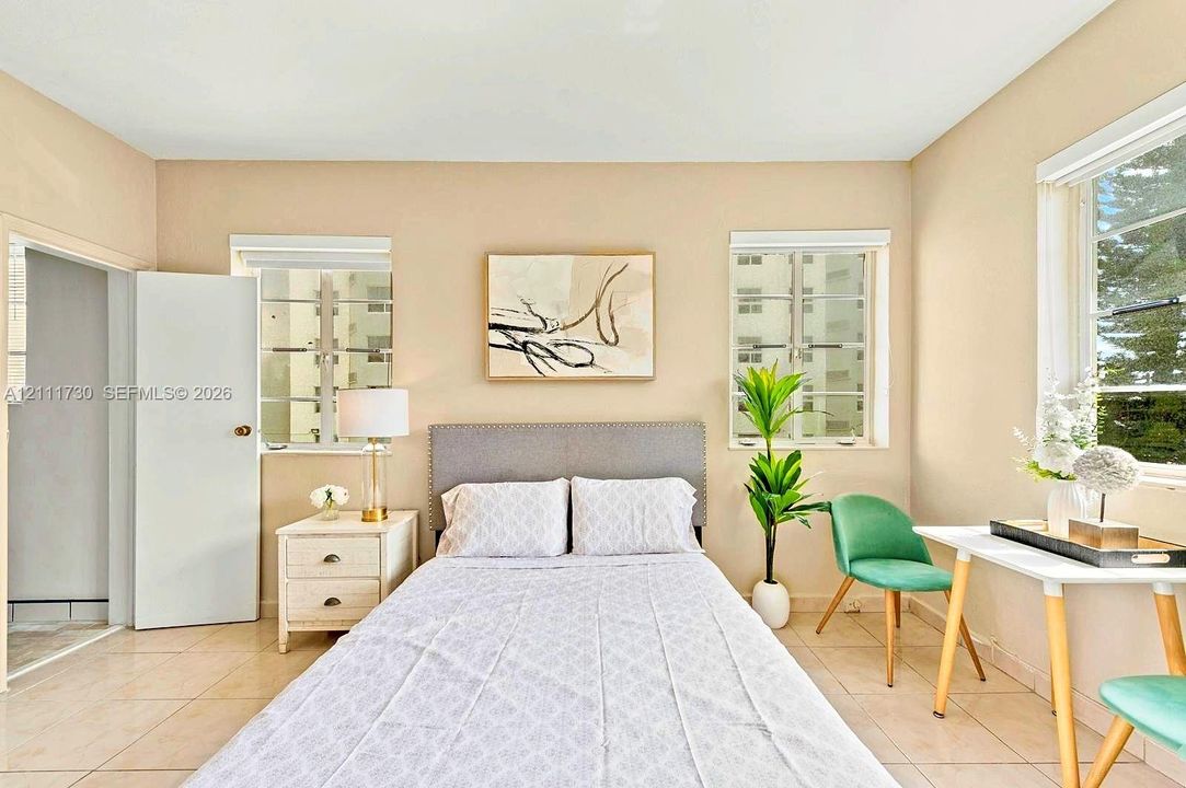Neutral-toned interior featuring ceramic tile flooring, dual-pane windows, and a classic swinging door