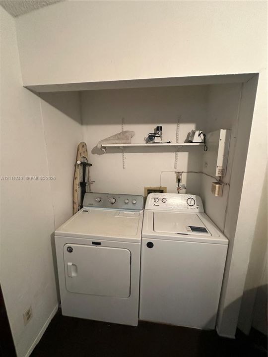 Laundry alcove featuring built-in shelving with adjustable wall-mounted tracks