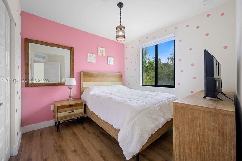 Wood-finish flooring, metal-cased single-hung window, and industrial-style hanging pendant light