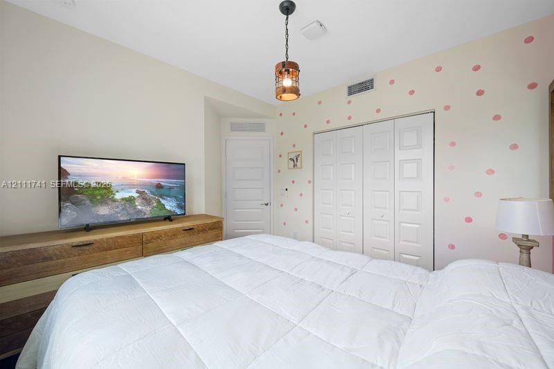 Interior room featuring a hanging metal and wood-finish pendant light, a bi-fold closet with paneled doors, and a multi-panel interior door