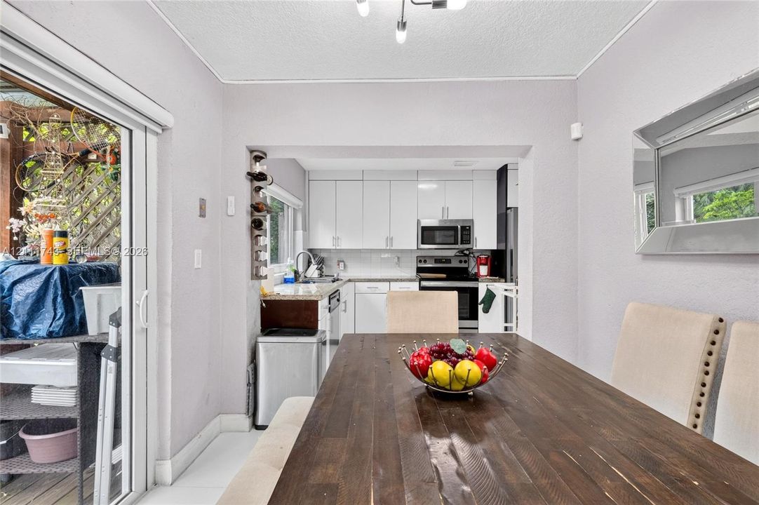 Kitchen featuring white shaker-style cabinetry, stone countertops, and built-in stainless steel appliances, including a microwave and range