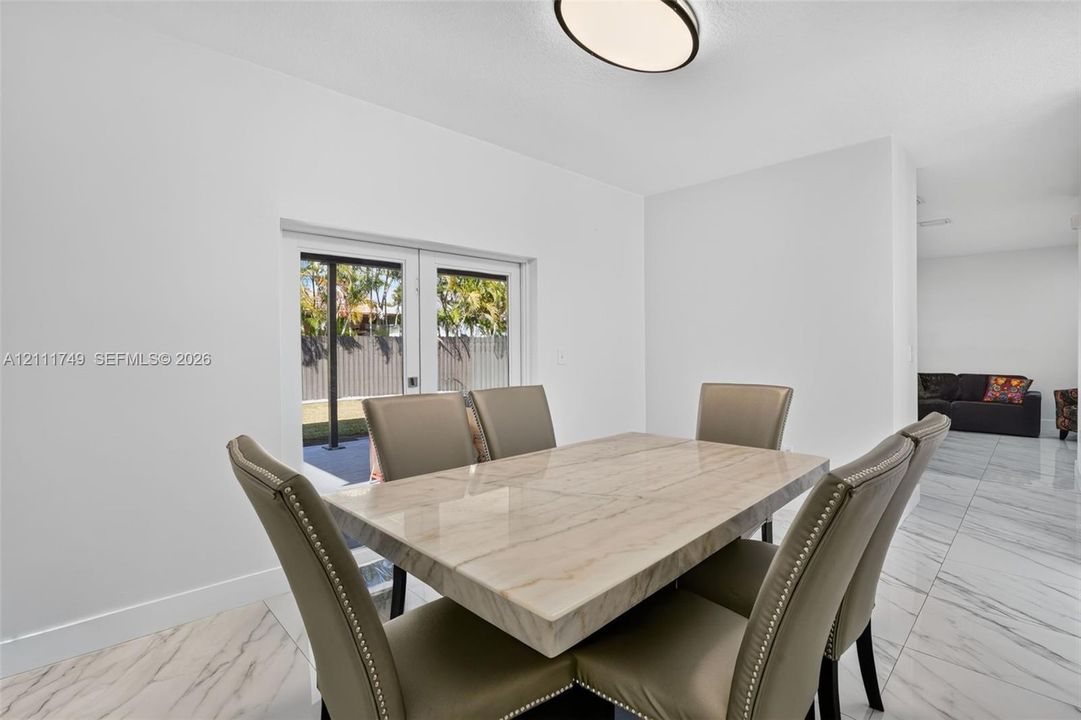 High-gloss marble-finish tile flooring, recessed ceiling lighting, and double-glass paneled exterior doors