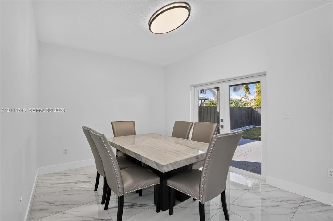 Large-format tile flooring, oval flush-mount ceiling lighting, and double-paned glass exterior doors