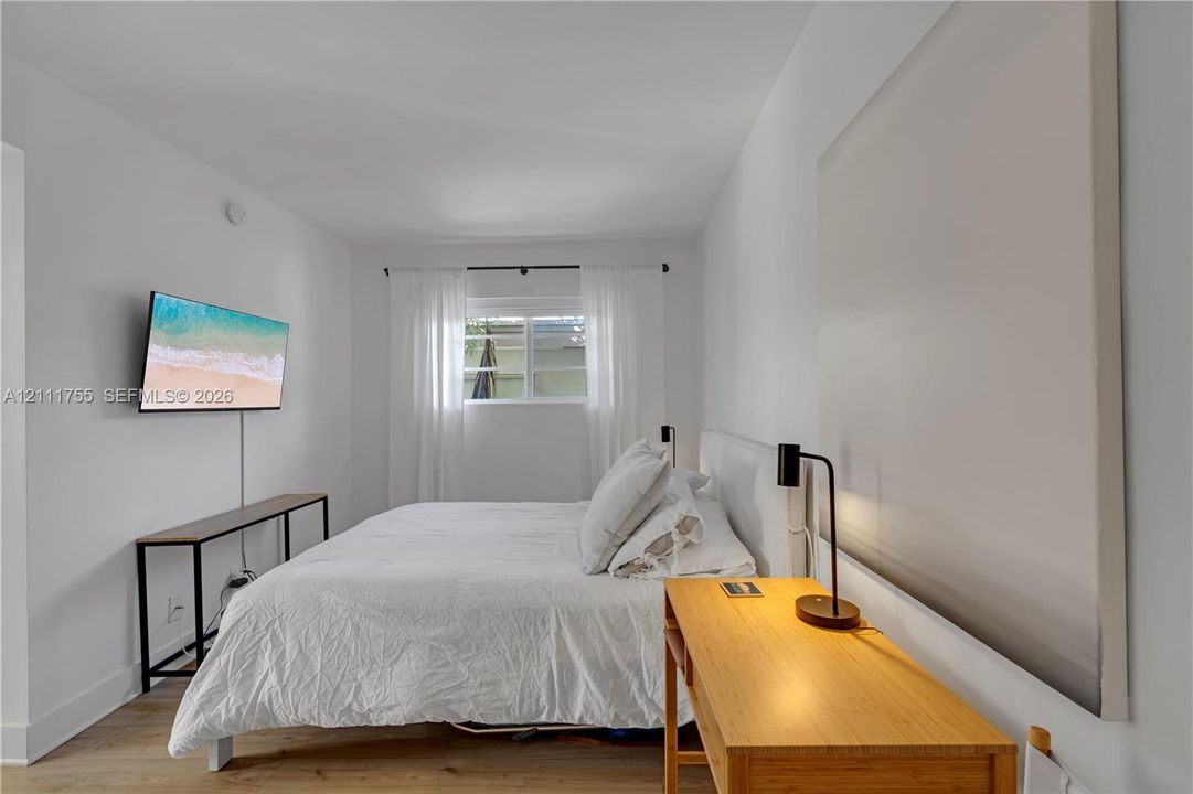 Neutral interior space featuring wood-finish flooring and a single-pane window