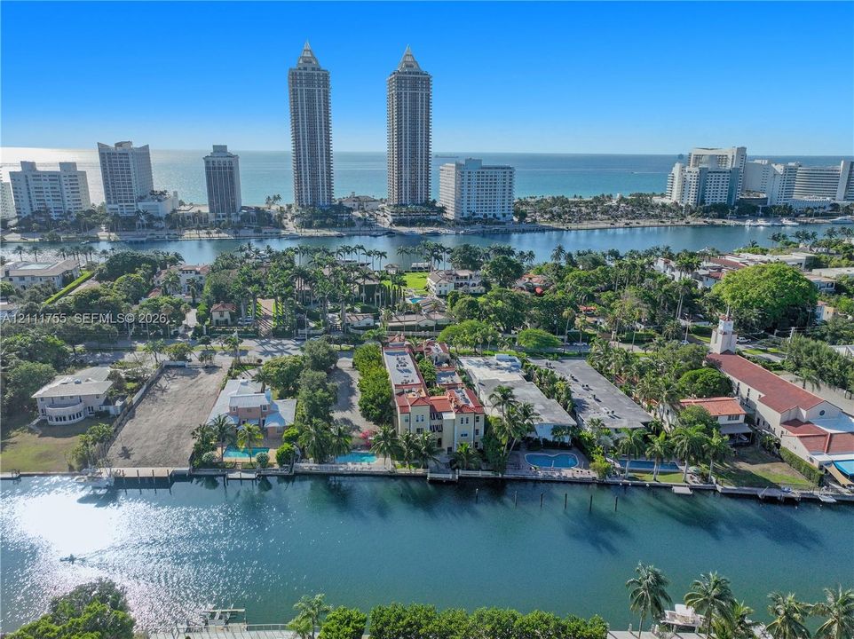 Aerial perspective featuring waterfront placement along a canal with mature tropical landscaping and deep-water access