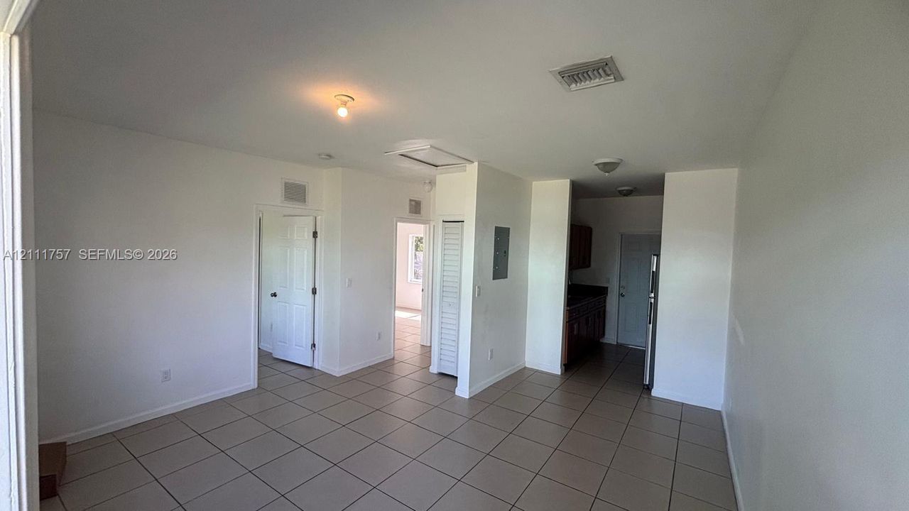 Interior space featuring neutral wall paint, large-format tile flooring, louvered closet doors, and recessed ceiling lighting