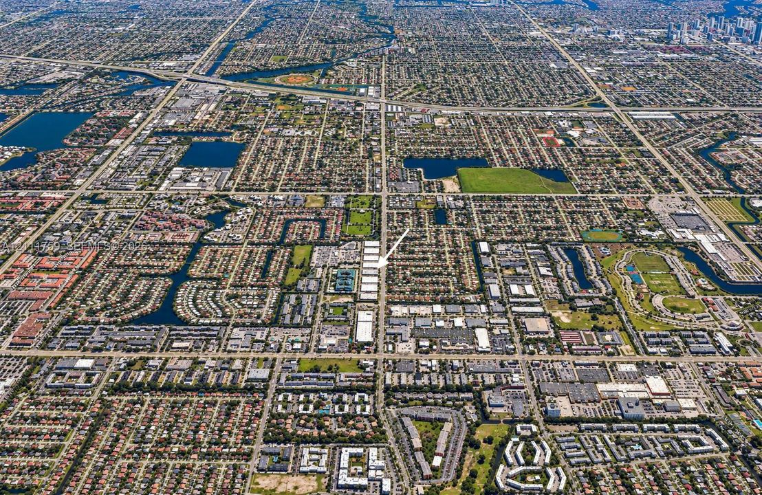 Aerial perspective featuring a gridded urban layout, established residential density, integrated waterway systems, and proximity to regional commercial corridors