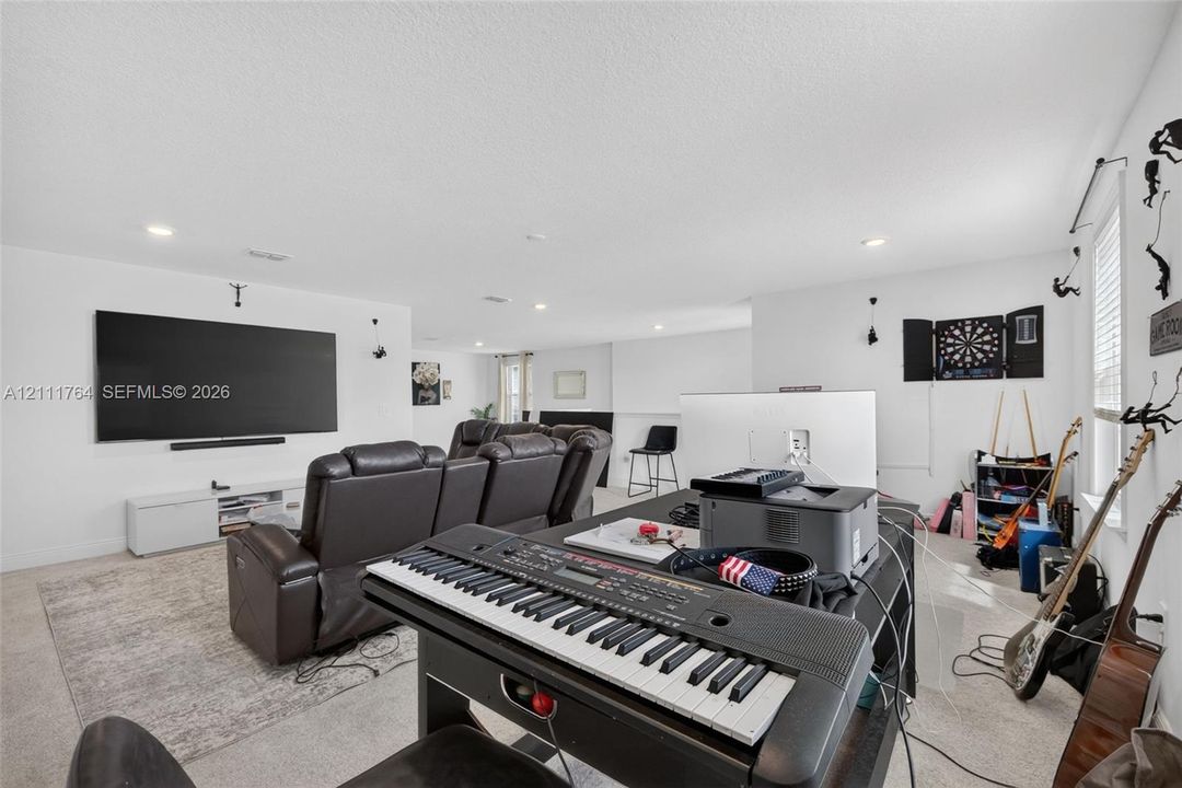 Spacious room featuring neutral carpeting, recessed lighting, and white walls