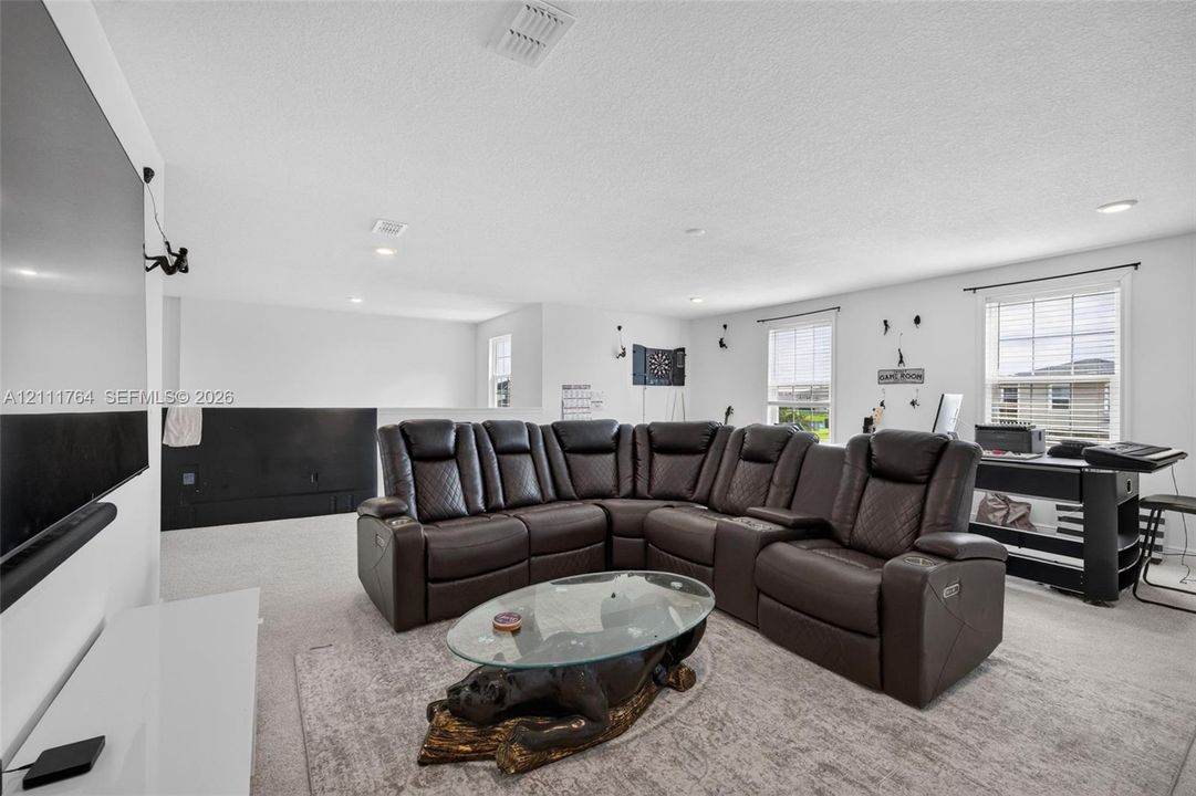 Open-concept space featuring recessed lighting, wall-to-wall carpeting, and multiple windows providing natural light