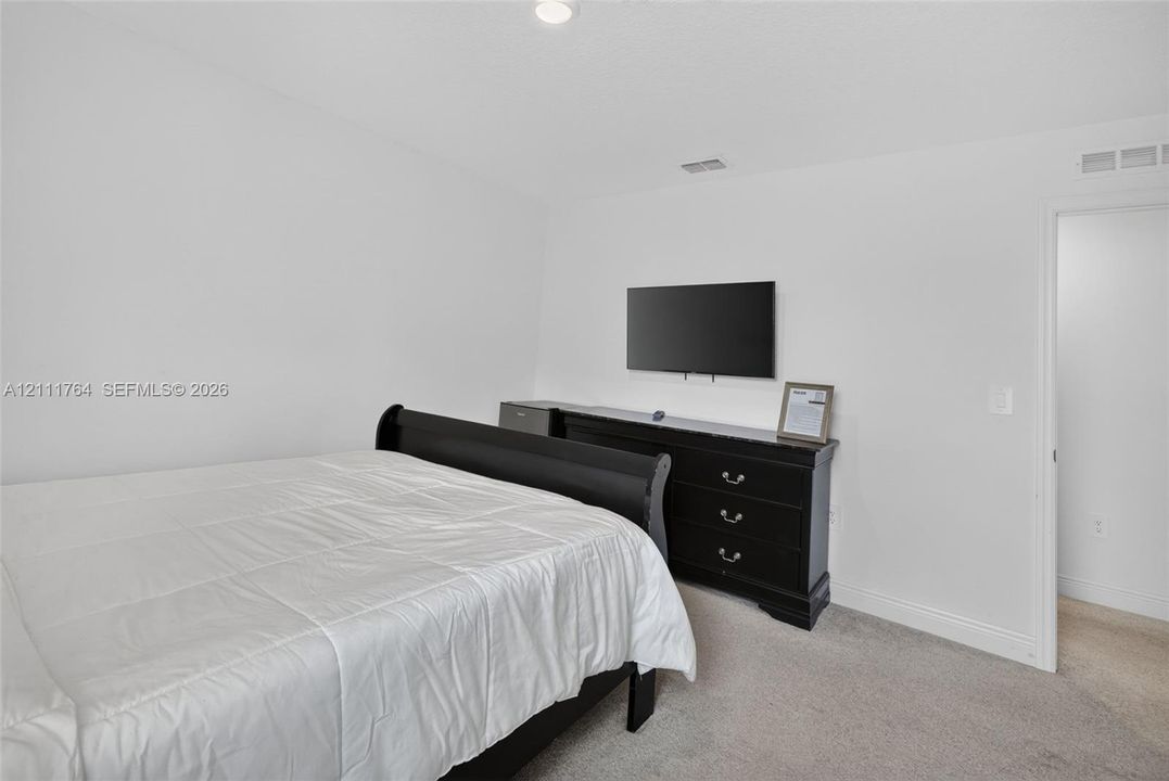 Neutral-toned interior space featuring wall-to-wall carpeting and recessed ceiling lighting