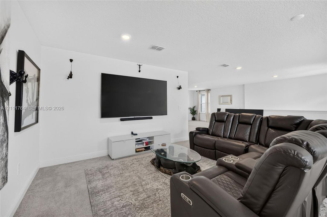 Neutral wall palette featuring recessed lighting and wall-mounted light fixtures