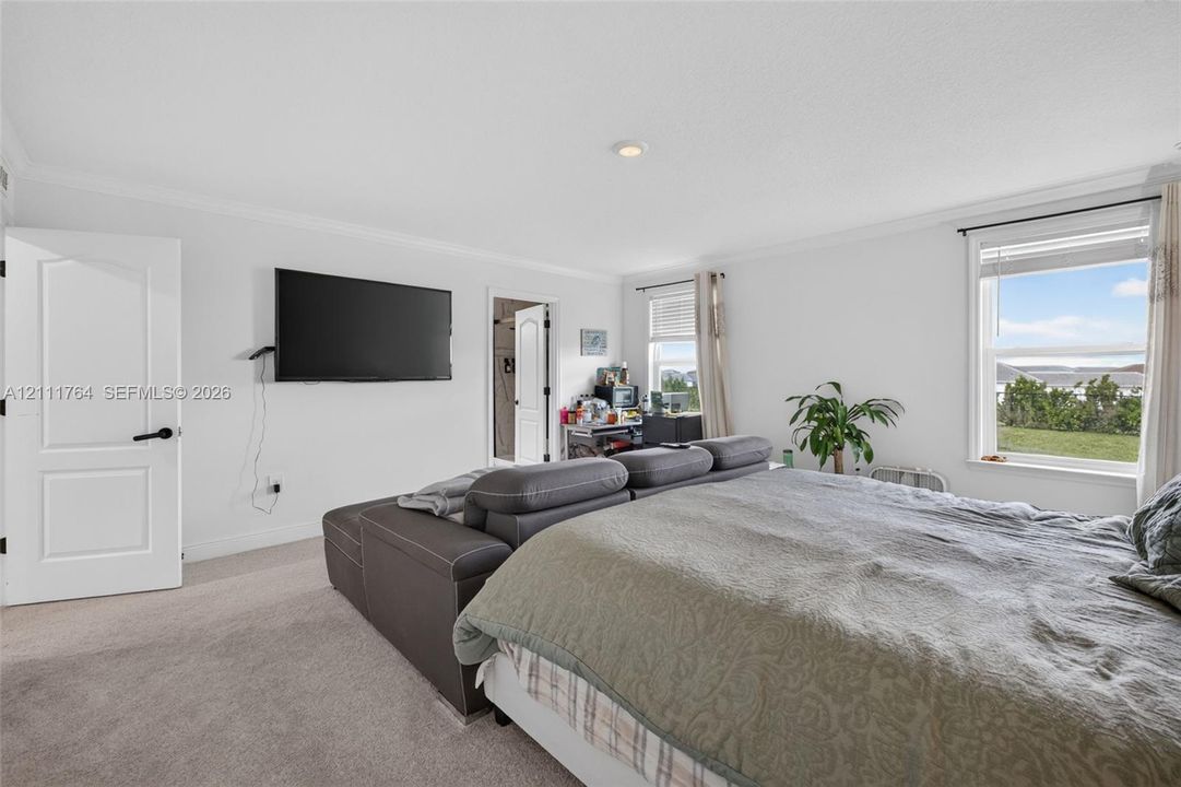Neutral wall coloring, carpeted flooring, recessed lighting, and multiple windows with exterior exposure
