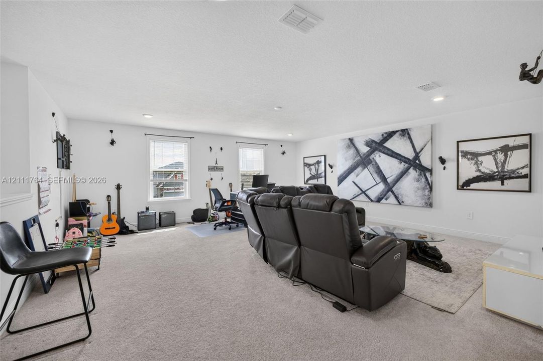 Expansive bonus room featuring neutral carpeting, recessed lighting, and multiple windows