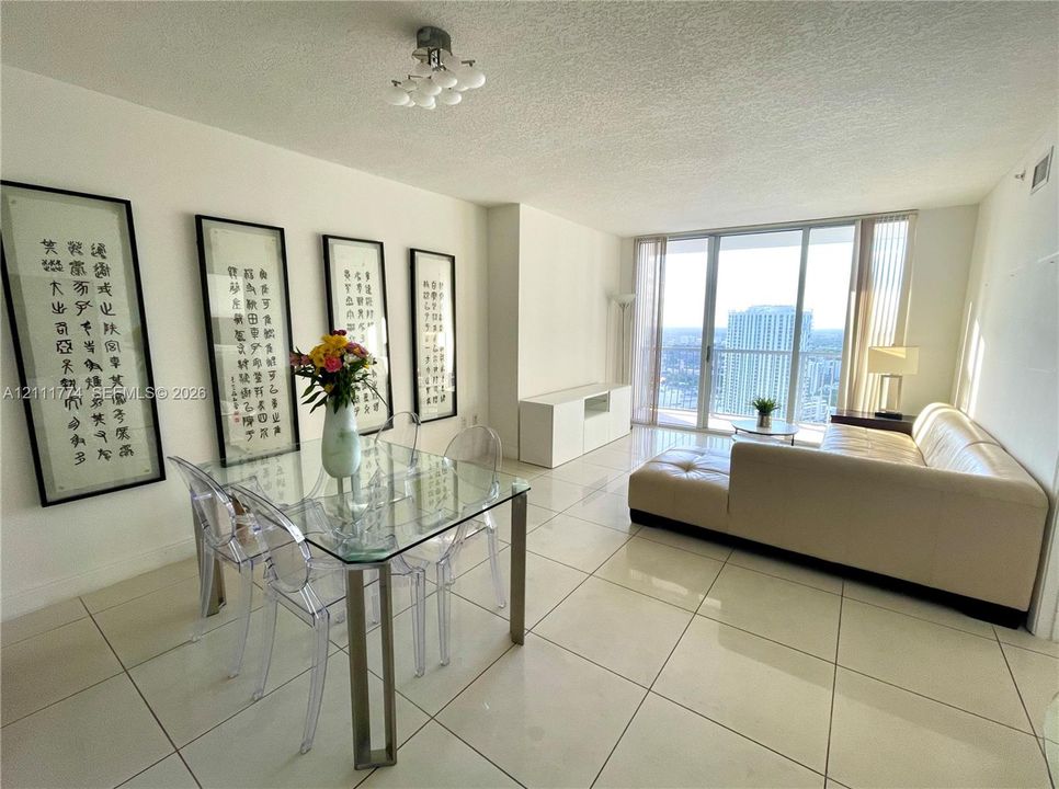 Floor-to-ceiling glass windows, polished tile flooring, built-in white cabinetry, and multi-light flush-mount ceiling fixture