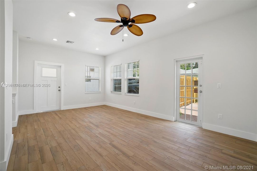 Interior space featuring wood-finish flooring, recessed lighting, a multi-blade ceiling fan, and a French-style glass door